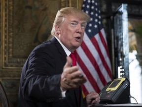 President Donald Trump turns to talk to the gathered media during a Christmas Eve video teleconference with members of the mIlitary at his Mar-a-Lago estate in Palm Beach, Fla., Sunday, Dec. 24, 2017.