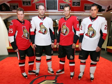 (L2R) Chris Neil, , Brian McGrattan, Jason Spezza and Chris Kelly model the new jerseys and uniforms inside the Sens locker room (new logo in the carpet, too... and just like in previous years, don't step on the -- new -- logo). The Ottawa Senators invited fans to Scotiabank Place this evening as the team introduced a "new look" (fitted) Reebok jersey and complete uniform. Aug. 22, 2007 @ Scotiabank Place.