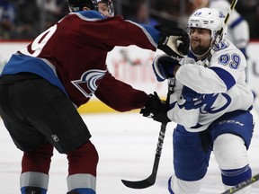 Colorado Avalanche defenseman Samuel Girard, left, hits Tampa Bay Lightning center Cory Conacher on the face as he drives to the net in the second period of an NHL hockey game Saturday, Dec. 16, 2017, in Denver.