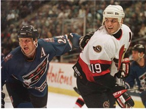 The Capitals' Mark Tinordi keeps close tabs on the Senators' Alexei Yashin during first period action.