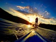 Stand-up paddle boarders make their way towards the setting sun at Meech Lake. (Photo by Ashley Fraser)