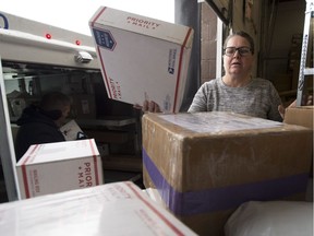 Betsy Smith piles up packages as they arrive via the United States Postal Service at their warehouse Monday December 18, 2017 in Ogdensburg, N.Y. Canadians have been increasingly shopping online, but scoring deals from U.S. retailers and getting them shipped right to their home has always been difficult, costly and sometimes impossible.