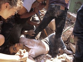 FILE - A man is rescued from a collapsed building in the Condesa neighborhood after an earthquake struck Mexico City on Sept. 19, 2017. The 7.1 earthquake stunned central Mexico, killing hundreds of people, injuring thousands and destroying countless buildings.