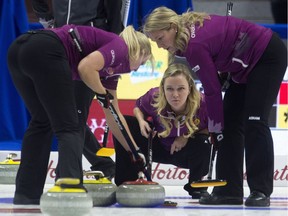 Chelsea Carey watches as Laine Peters, left, and Cathy Overton-Clapham follow a shot into the rings during Wednesday afternoon's game against the Jennifer Jones foursome.