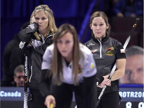Jennifer Jones, top left, and Kaitlyn Lawes look over the shoulder of Rachel Homan as she directs her teammates from the house during the final draw of the preliminary round on Friday night. Homan's team won the game, but it meant nothing in the standings and the same teams will meet again in the women's semifinal on Saturday afternoon.