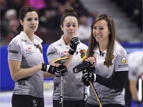 Rachel Homan smiles at the end of the eighth end of Friday night's game as Lisa, left, Weagle and Joanne Courtney look on at Canadian Tire Centre.