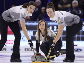 Skip Rachel Homan looks down the sheet as lead Lisa Weagle, left, and second Joanne Courtney sweep in front of her rock during the women's semifinal draw against Team Jones at the 2017 Roar of the Rings Canadian Olympic Trials in Ottawa on Saturday, Dec. 9, 2017.