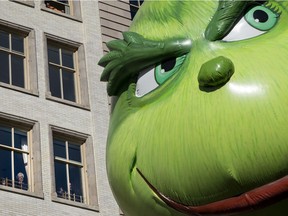 The Grinch balloon passes by windows of a building on Central Park West during Macy's Thanksgiving Day Parade in New York Thursday, Nov. 23, 2017. Grinch-like economists, says Mike Callaghan, have it all wrong about Christmas.