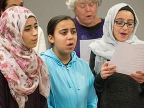 The One World Choir is made up of refugees and new Canadians such as (from left in front) Sara Ali, Esra Mohammed, and Alaa Moustafa, who gather every week for singing and companionship.