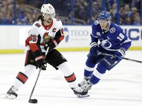 Ottawa Senators defenseman Erik Karlsson (65) carries the puck past Tampa Bay Lightning left wing Ondrej Palat (18) during the first period of an NHL hockey game Thursday, Dec. 21, 2017, in Tampa, Fla.