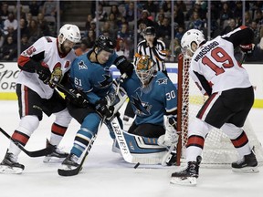 San Jose Sharks goalie Aaron Dell (30) stops a shot next to teammate Justin Braun (61) and Ottawa Senators' Zack Smith, left, and Derick Brassard (19) during the first period of an NHL hockey game Saturday, Dec. 9, 2017, in San Jose, Calif.