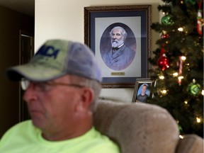 Reggie Dickerson sits near a portrait of Confederate Gen. Robert E. Lee, next to a photo of his son, and a Christmas tree at his home in Sandy Hook, Ky., Wednesday, Dec. 13, 2017. To Dickerson, President Barack Obama has come to represent all the things he believes have gone awry. There are the environmental regulations to try to curb carbon emissions that many blame for the decimation of the coal business. But Obama has also become a symbol to him of a changing nation: gay marriage, immigrants, lost blue collar jobs that left families on welfare, a widely-held fear that the government would take their guns if it had its way.