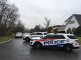 Kingston Police vehicles block access to Graceland Avenue in Kingston, Ont. on Tuesday, Dec. 5, 2017. Police were called to the area after reports of a man with a gun inside. When police entered they found an elderly woman dead and the elderly man with critical injuries.