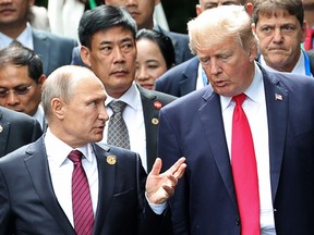 U.S. President Donald Trump, right, and Russia's President Vladimir Putin talk during the family photo session at the APEC Summit in Danang, Saturday, Nov. 11, 2017.