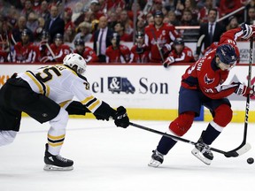 Boston Bruins defenseman Brandon Carlo (25) and Washington Capitals right wing Alex Chiasson (39) vie for the puck during the second period of an NHL hockey game Thursday, Dec. 28, 2017, in Washington.