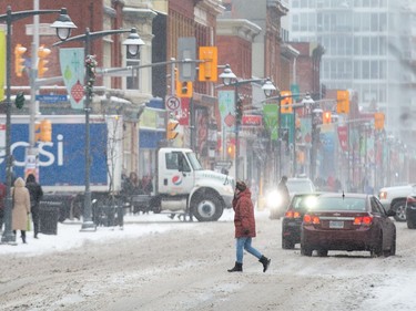 Pedestrians and traffic along Bank St as the region begins to deal with the first major snowfall of the winter.