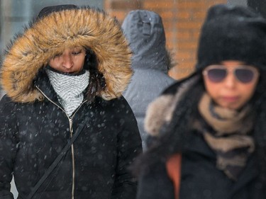 Pedestrians trudge along Bank St as the region begins to deal with the first major snowfall of the winter.