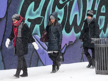 Pedestrians trudge along Bank St as the region begins to deal with the first major snowfall of the winter.