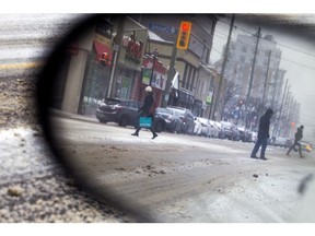 Shoppers cross Richmond Road amid the parked cars on a December day. (Photo: Ashley Fraser/Postmedia)