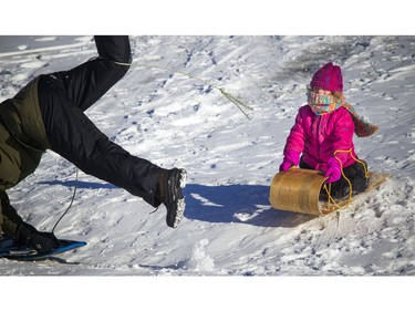 Five-year-old Zoë White was giggling as Steve White jokingly dives out of the way of her toboggan at Westboro Beach.