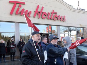 Members of Ontario Federation of Labour protest outside a Tim Hortons Franchise in Toronto on Wednesday January 10, 2018. Protesters angered by some Ontario Tim Hortons franchisees who slashed workers' benefits and breaks after the province raised minimum wage will demonstrate across the country tomorrow.