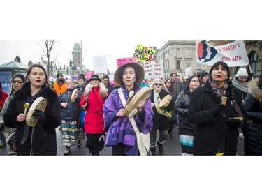 Ogimaakwewak Singers, including Marissa Mills, middle, lead the march off of Parliament Hill and down Wellington Street with traditional drumming and singing.