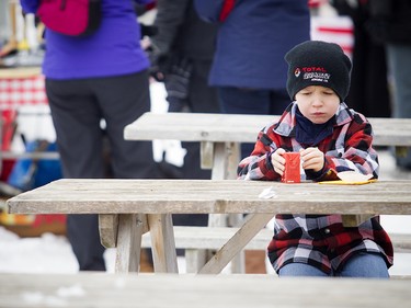 Six-year-old Sean Walton takes a little snack break Saturday afternoon beside the rink.