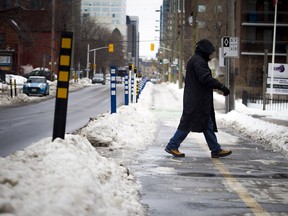 People walk along O'Connor Street, making sure to avoid the ice.   Ashley Fraser/Postmedia