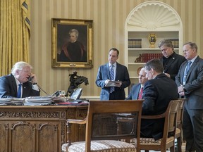 In this Jan. 28, 2017 file photo, President Donald Trump, accompanied by from second from left, Chief of Staff Reince Priebus, Vice President Mike Pence, National Security Adviser Michael Flynn, Senior Adviser Steve Bannon, and White House press secretary Sean Spicer, speaks on the phone with Russian President Vladimir Putin