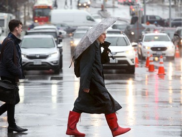 12: 33 p.m. The intersection at Elgin and Laurier was slick with rain as people made their way around downtown during lunch hour.  Ottawa was hit with some weird weather Friday, with balmy temperatures and rainy weather earlier in the day, giving way to cold, wind and snow later in the day. Julie Oliver/Postmedia