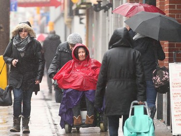 12:50 p.m. People were covering up with raincoats and umbrellas as the rain picked up around noon downtown on Elgin Street.  Ottawa was hit with some weird weather Friday, with balmy temperatures and rainy weather earlier in the day, giving way to cold, wind and snow later in the day. Julie Oliver/Postmedia