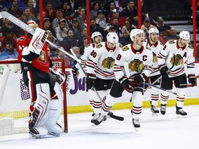 Ottawa Senators Craig Anderson adjust his mask as Chicago Blackhawks Jonathan Toews leads his team back to the bench after celebrating a second-period goal during NHL action at Canadian Tire Centre in Ottawa on Jan. 9. Errol McGihon/Postmedia