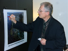Ole Hendrickson of the Concerned Citizens of Renfrew County and Area makes his mark on an aerial photo of the Chalk River Labs site which is used to focus love and prayers on it and the Ottawa River.