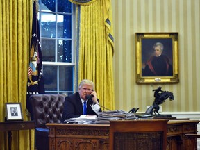 U.S. President Donald Trump speaks on the phone with Australia's Prime Minister Malcolm Turnbull from the Oval Office of the White House on January 28, 2017, in Washington, DC.