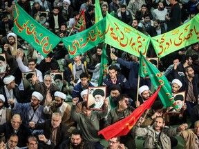 TOPSHOT - Iranians chant slogans as they march in support of the government near the Imam Khomeini grand mosque in the capital Tehran on December 30, 2017. Tens of thousands of regime supporters marched in cities across Iran in a show of strength for the regime after two days of angry protests directed against the country's religious rulers.