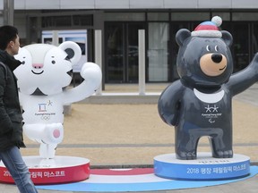 A man passes by official mascots of the 2018 Pyeongchang Winter Games, a white tiger "Soohorang" for the Olympic, and the Asiatic black bear "Bandabi" for the Paralympic, in downtown Seoul, South Korea, Monday, Jan. 8, 2018. South Korean President Moon Jae-in's government wants North Korea to take part in the Feb. 9-25 Games to use it as a chance to tamper down animosities between the rivals split along the world's heavily fortified border.