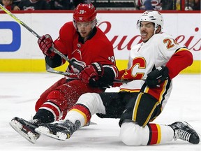 Carolina Hurricanes' Elias Lindholm (28) collides with Calgary Flames' Travis Hamonic (24) during the second period of an NHL hockey game, Sunday, Jan. 14, 2018, in Raleigh, N.C.