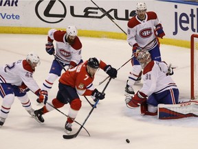 Panthers' Colton Sceviour (7) moves the puck as Canadiens' Byron Froese (42), Jordie Benn (8) Jeff Petry, top right, and goalie Carey Price defend on Saturday, Dec. 30, 2017, in Sunrise, Fla.