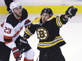 Bruins winger Brad Marchand, right, reaches for the puck in front of Devils wingerStefan Noesen (23) during the first period of Tuesday's game.