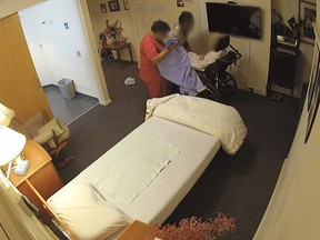Still from video of personal support workers preparing a severely disabled woman for bed in her room at Peter D. Clark long-term care home.