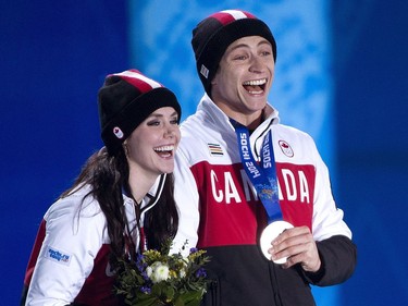 Canadians Tessa Virtue, left, and Scott Moir react as they receive their silver medals for ice dancing at the medal ceremony during the 2014 Sochi Winter Olympics in Sochi, Russia on Tuesday, February 18, 2014.