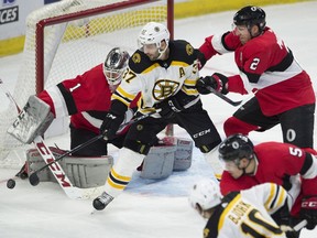 Ottawa Senators defenceman Dion Phaneuf (2) tries to clear Boston Bruins centre Patrice Bergeron (37) from in front of Senators goaltender Mike Condon (1) during second period NHL action Thursday January 25, 2018 in Ottawa.