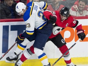 Ottawa Senators defenceman Erik Karlsson (65) battles with St. Louis Blues right wing Dmitrij Jaskin (23) along the boards during first period NHL hockey action in Ottawa on Thursday, January 18, 2018.