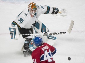Sharks goaltender Aaron Dell comes out to clear the puck as Canadiens forward Paul Byron moves in during the first period.