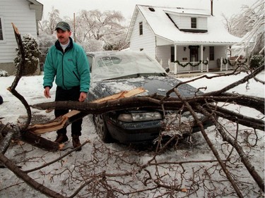 Scott Lucas on Churchill Ave in Ottawa removes large tree branches from a car after a severe ice storm hit Jan, 08,1998.  More than three million people were affected by the ice storm that was devastating but also produced images of rare beauty.
