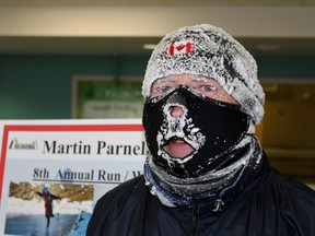 Cochrane's Marathon Man Martin Parnell tries to warm up after completing 42 bone-chilling kilometres as part of a fundraiser to help build an ice skating rink for girls in Afghanistan. Supplied photo