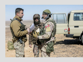 A member of the Canadian military discusses JTAC training in Jordan with Jordanian military personnel. DND photo.
