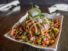 Kinki Lounge Kitchen's Mac Daddy's Bacon Cheese Burger Poutine with cheeseburger, bacon, curds, chredded cheddar, beef gravy, scallions, pickles, jalapenos, lemon garlic mayo