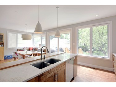 The kitchen now overlooks the dining area with large windows looking out to the backyard.