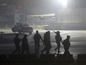 Security forces walk towards the Intercontinental Hotel after a deadly attack in Kabul, Afghanistan, Saturday, Jan. 20, 2018. An Afghan official says that a group of gunmen have attacked the Intercontinental Hotel in the capital Kabul.